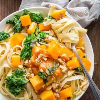 Bowl of Butternut Squash Pasta with a Cluster of Noodles Wrapped Around a Fork