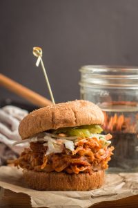 Jackfruit Pulled Pork Sandwich with a Water Glass and Skillet in the Background