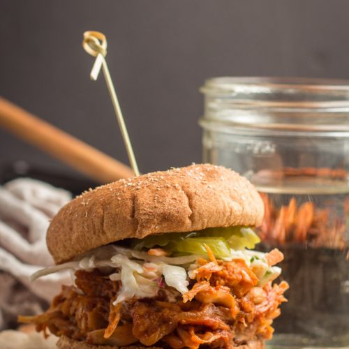 Jackfruit Pulled Pork Sandwich with a Water Glass and Skillet in the Background