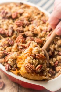 Wooden Spoon Scooping Sweet Potato Casserole From a Baking Dish