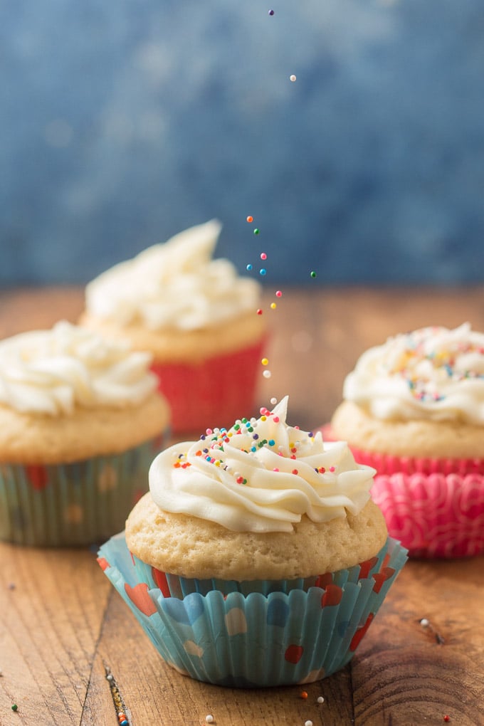Sprinkles Being Dropped onto a Frosting-Topped Vegan Vanilla Cupcake