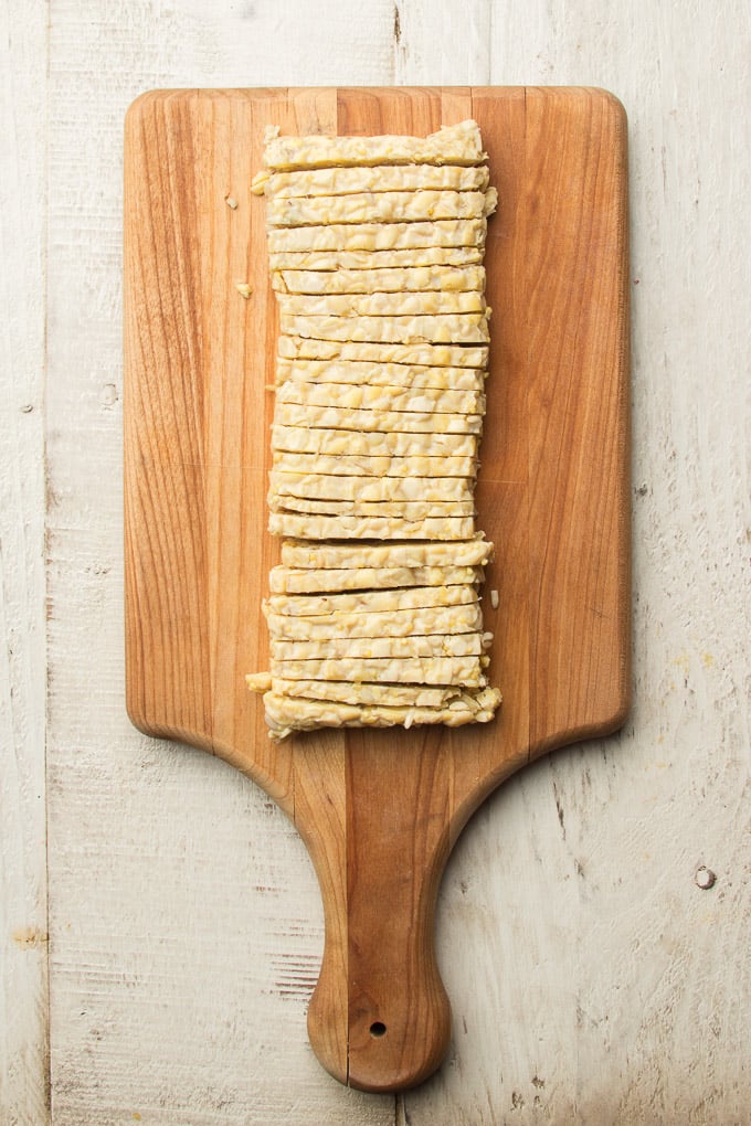 Thinly Sliced Tempeh on a Cutting Board