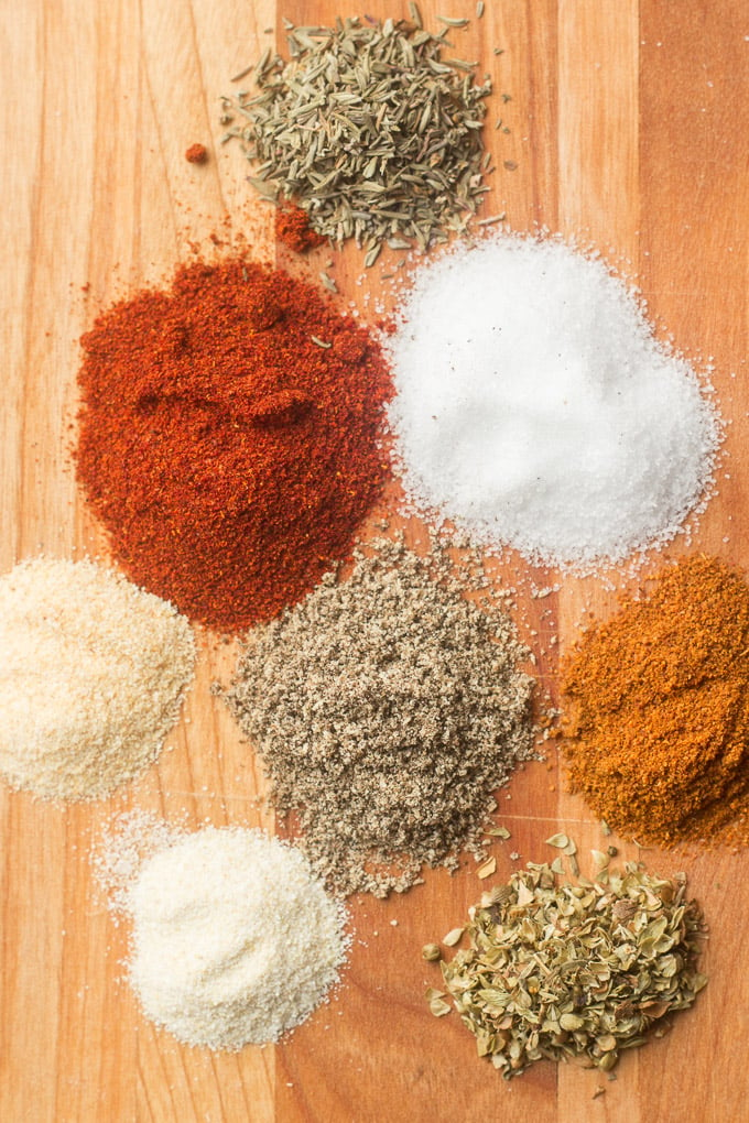 Spices Used To Make Blackened Seasoning Arranged in Mounds on a Wooden Cutting Board