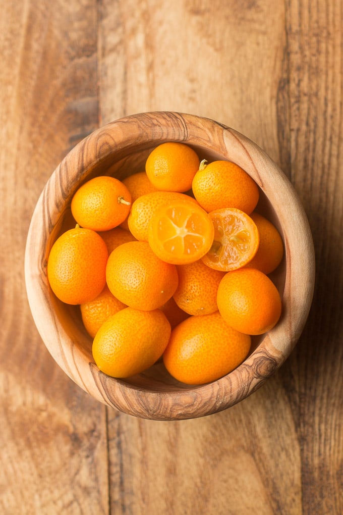 Bowl of Kumquats on a Wooden Surface
