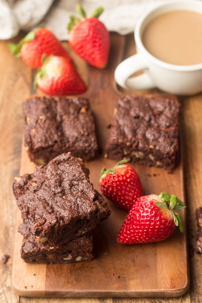 Vegan Brownies Arranged on Wooden Surface with Coffee Cup, and Strawberries