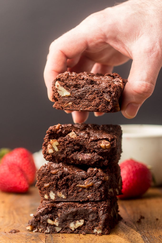 Hand Grabbing a Vegan Brownie From a Stack