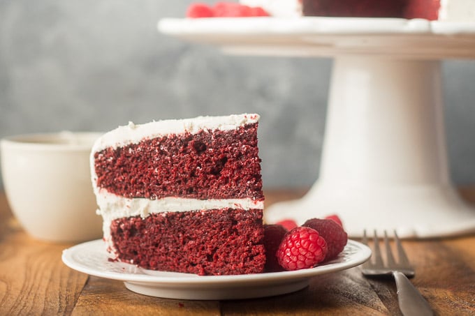 Slice of Vegan Red Velvet Cake on a Plate with Raspberries