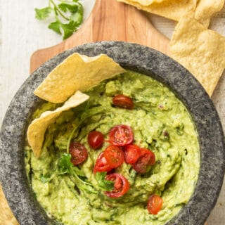 Guacamole Topped with Tomatoes and Cilantro in a Molcajete