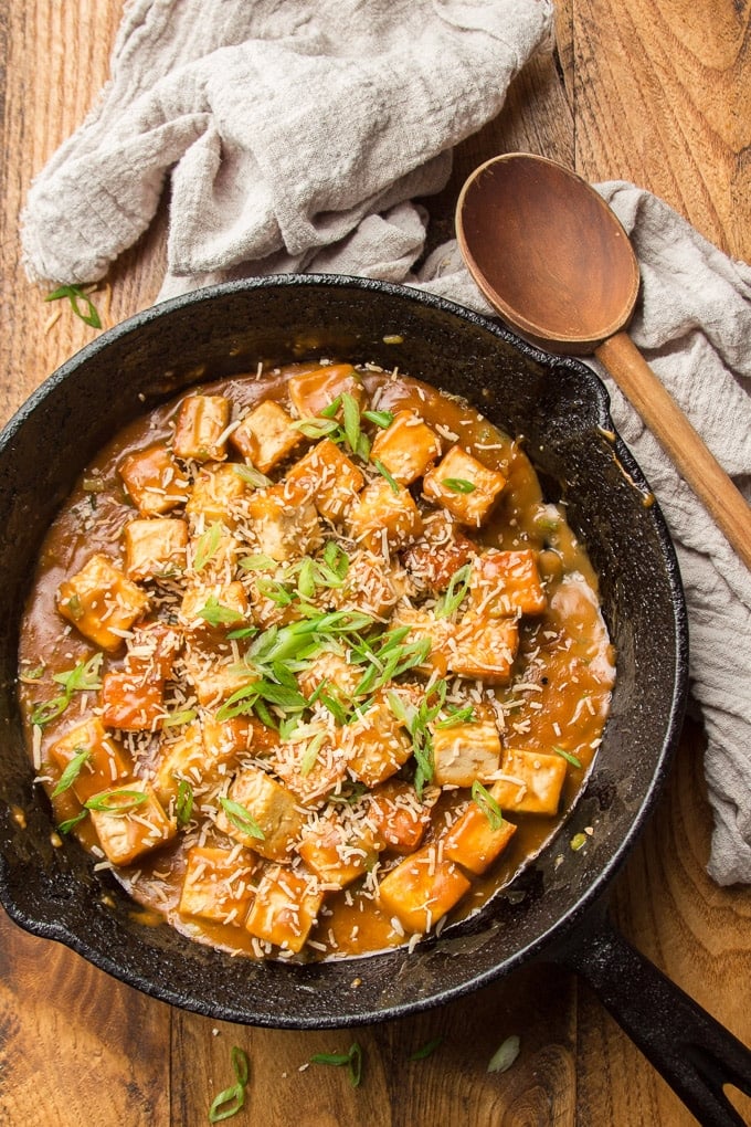 Skillet of Sweet & Sticky Coconut Tofu with Wooden Spoon on the Side