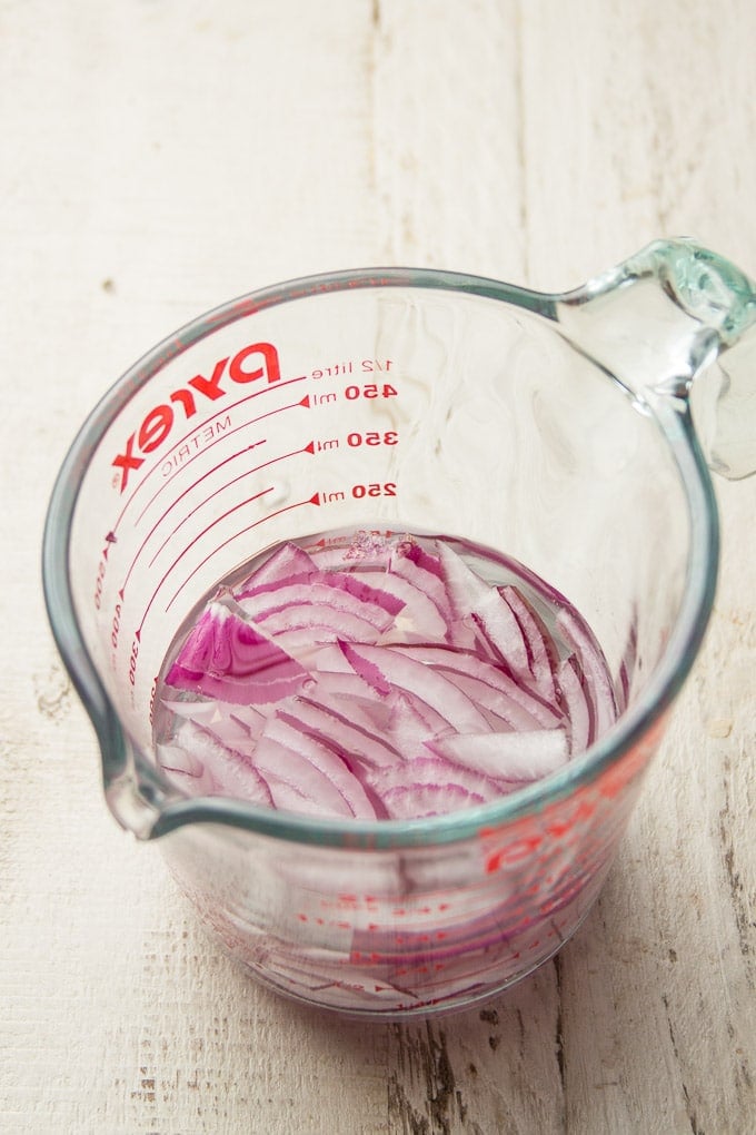 Red Onion Slices Soaking in a Liquid Measuring Cup