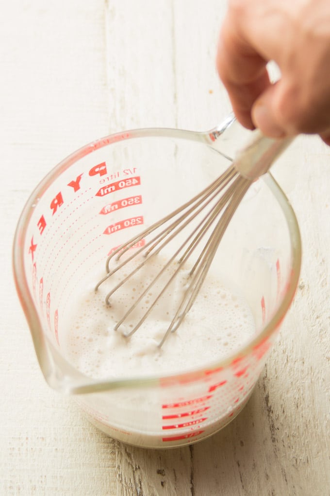 Hand Whisking Non-Dairy Milk and Cornstarch Together in a Liquid Measuring Cup