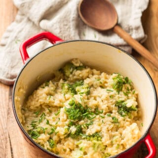 Pot of Vegan Broccoli Cheese Risotto with Napkin and Wooden Spoon in the Background