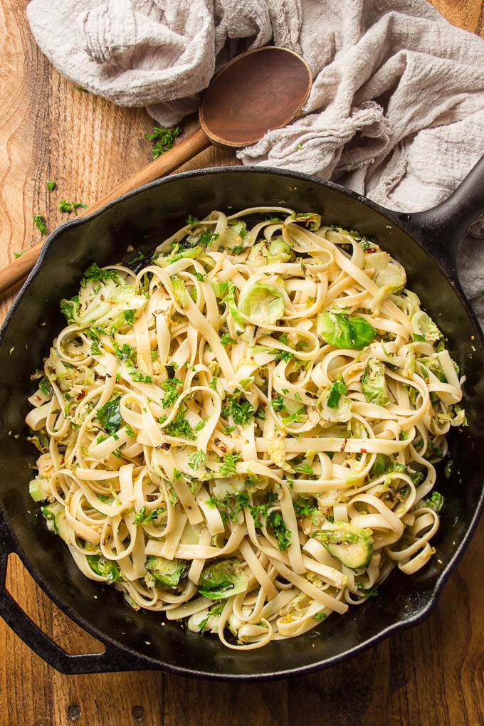 Skillet of Brussels Sprout Pasta on a Wooden Surface with Spoon