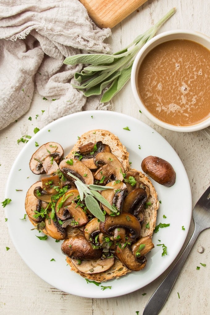 White Wooden Table Set with Coffee Cup, Bunch of Sage, and Plate of Mushrooms on Toast
