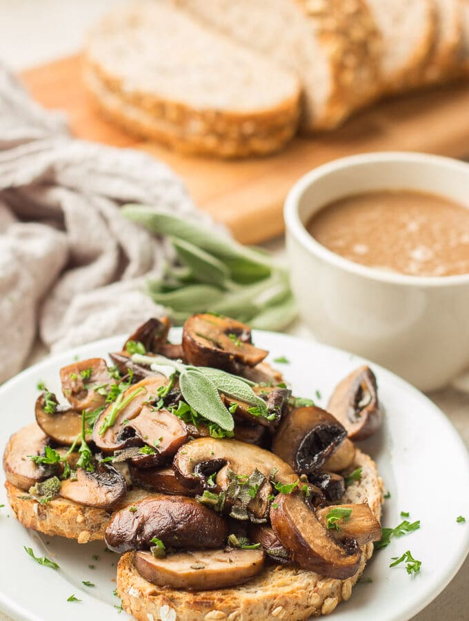 Plate of Mushrooms on Toast with Coffee Cup and Loaf of Bread in the Background