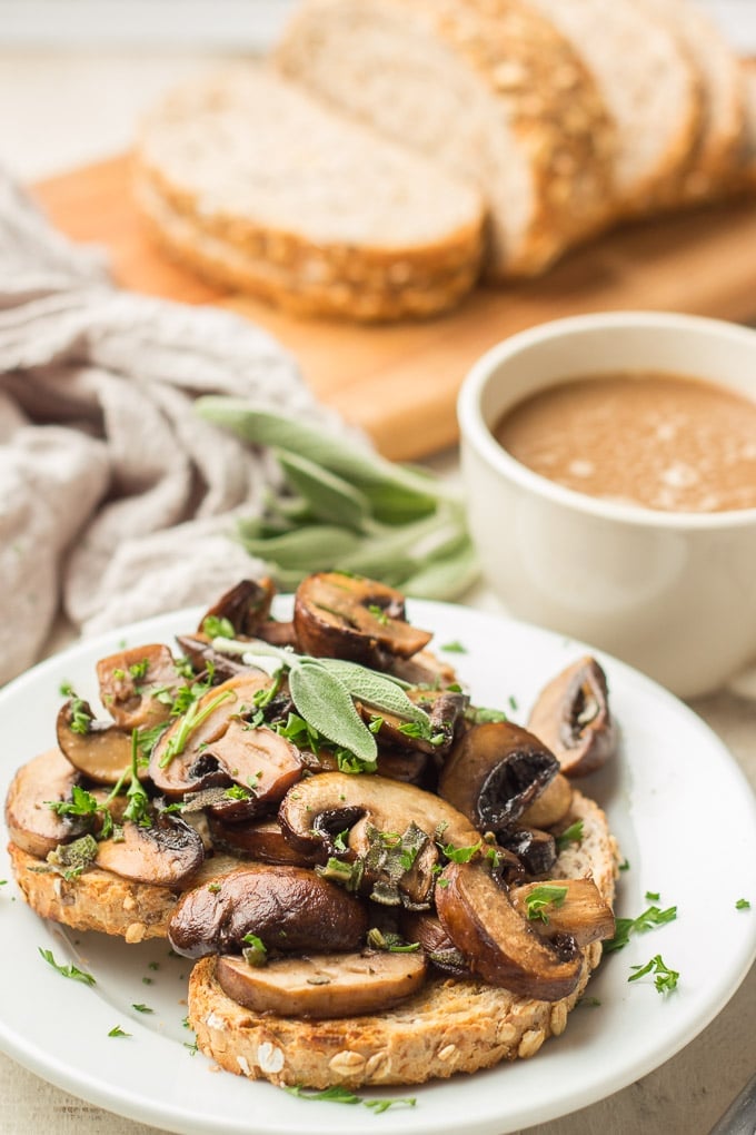 Plate of Mushrooms on Toast with Coffee Cup and Loaf of Bread in the Background