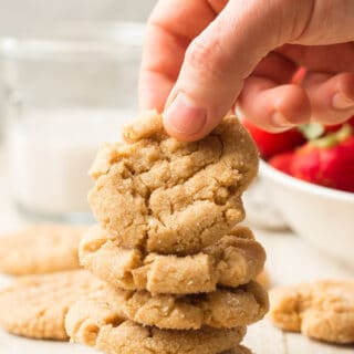 Hand Grabbing a Vegan Peanut Butter Cookie From a Stack