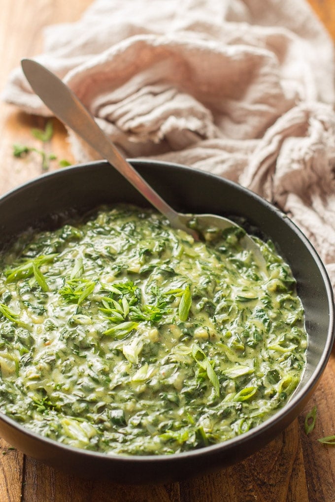 Close Up of Vegan Creamed Spinach in a Bowl with Serving Spoon