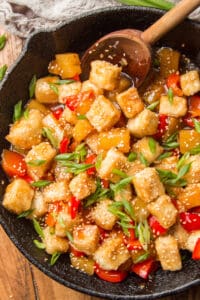 Close Up of Sweet & Sour Tofu in a Skillet with Wooden Spoon