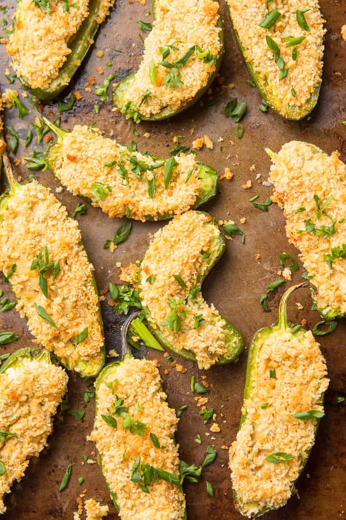 Vegan Jalapeño Poppers Topped with Chives on a Distressed Baking Sheet