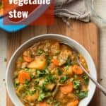Bowl of Vegetable Stew on a Wooden Surface with Text Overlay Reading "Vegetable Stew"
