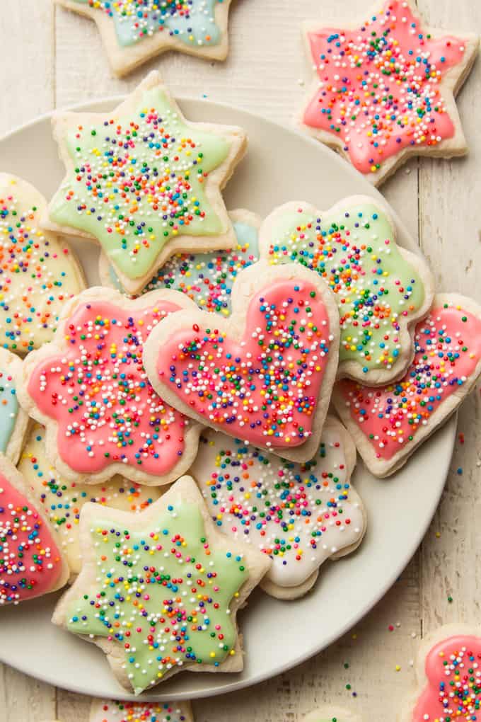 Vegan Sugar Cookies Topped with Colored Frosting and Sprinkles on a Plate