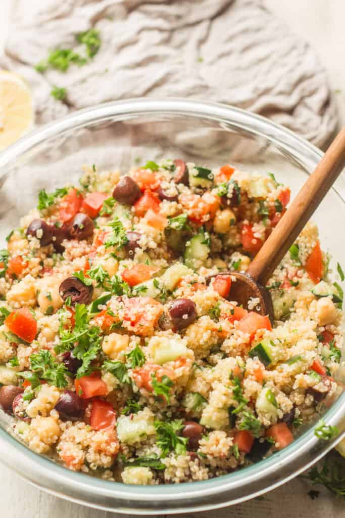 Close Up of Mediterranean Quinoa Salad in a Bowl with Wooden Spoon