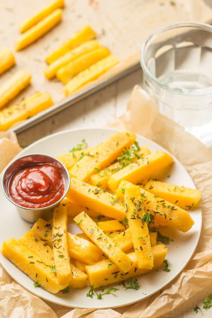 Plate of Herbed Polenta Fries with Baking Sheet in the Background