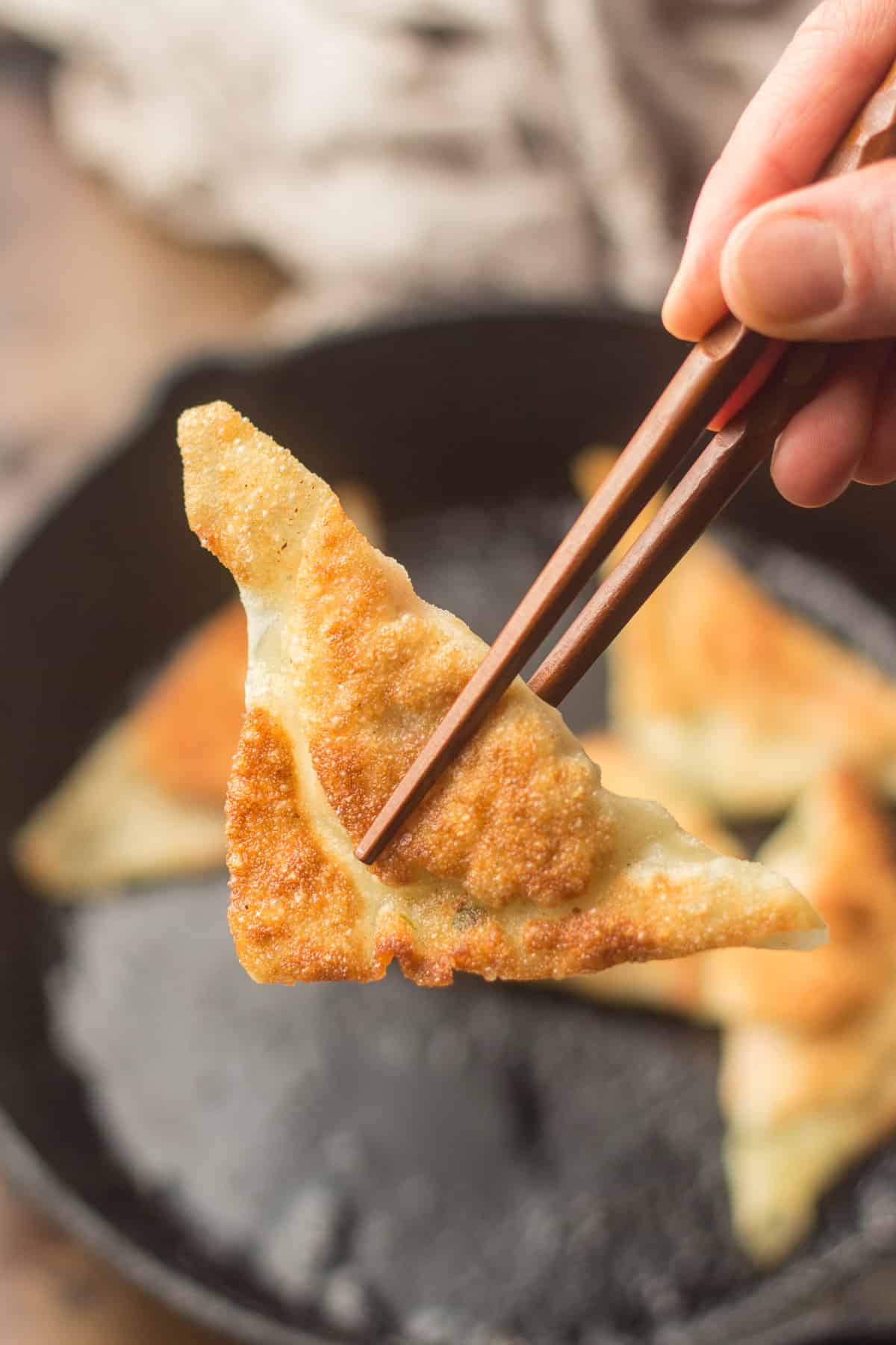 Close Up of a Tofu Dumpling Held Between Two Chopsticks