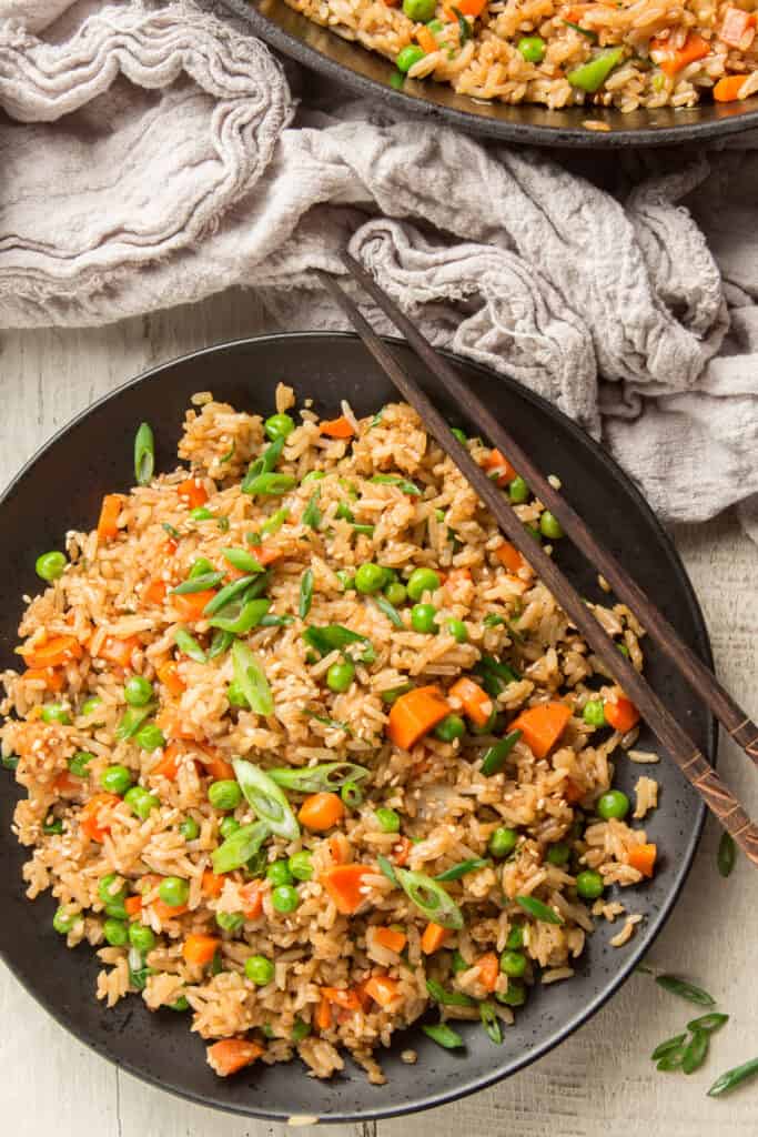 Plate of Vegan Fried rice with chopsticks on the side.