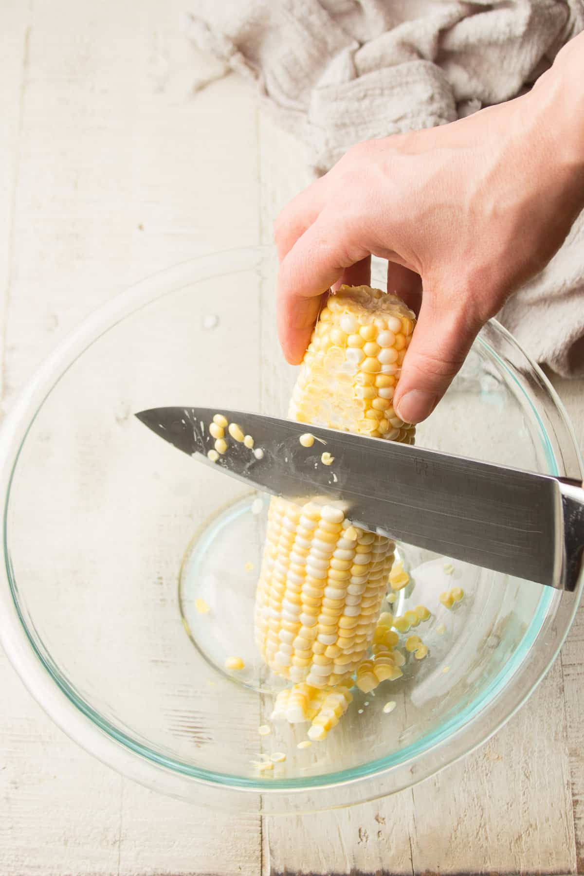 Cortar el maíz de una mazorca a mano.