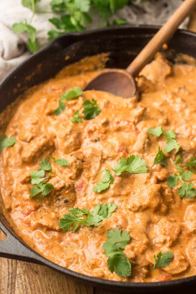 Vegan Butter Chicken in a Skillet with Wooden Spoon