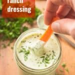 Hand Dipping Carrot Stick into a Jar of Vegan Ranch Dressing with Text Overlay Reading "Vegan Ranch Dressing"
