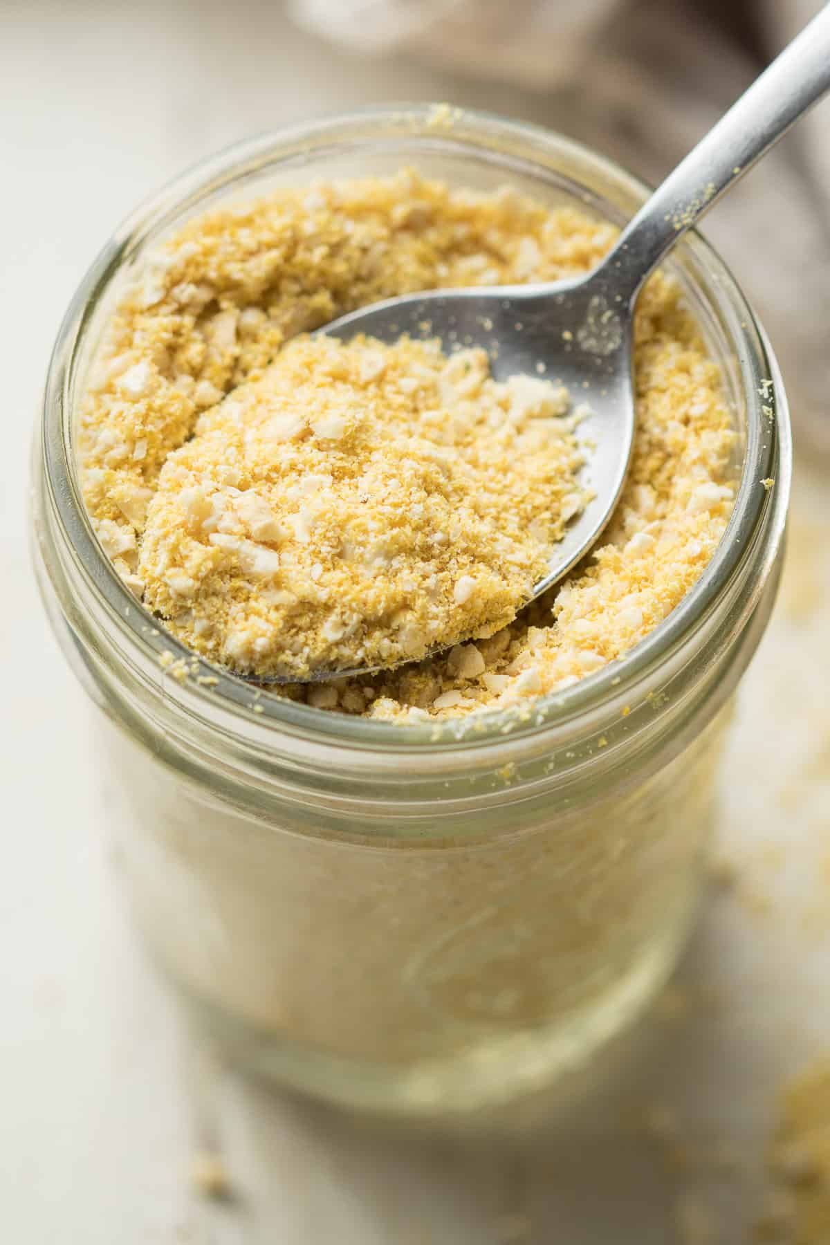 Spoon Scooping Vegan Parmesan Cheese from a Jar