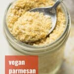 Spoon Scooping Vegan Parmesan Cheese from a Jar with Text Overlay Reading "Vegan Parmesan Cheese"