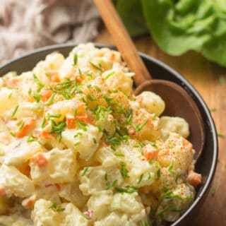 Close up of Vegan Potato Salad in a Bowl with Serving Spoon