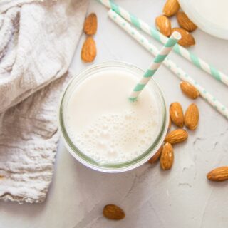 Glass of Almond Milk Surrounded By Almonds
