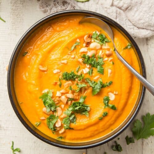Bowl of Thai Carrot Soup with Peanuts and Cilantro on Top