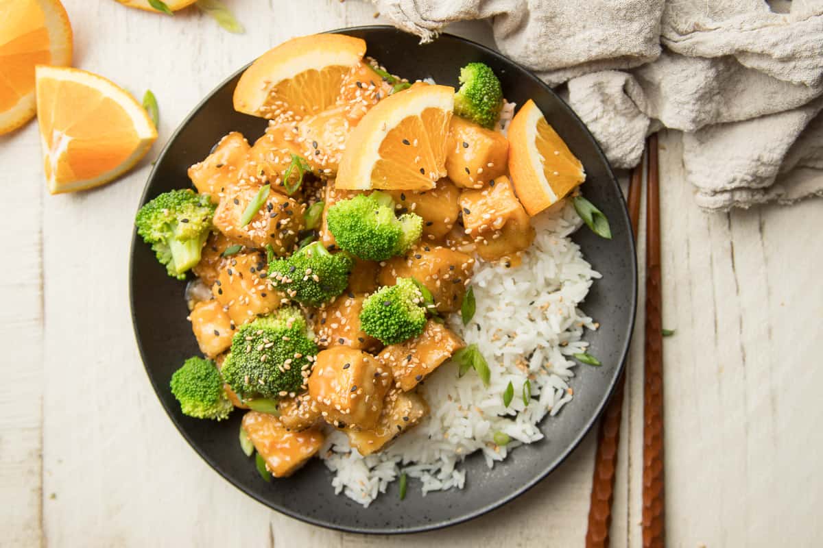 Plate of Crispy Orange Tofu, Rice and Broccoli with Chopsticks on the Side
