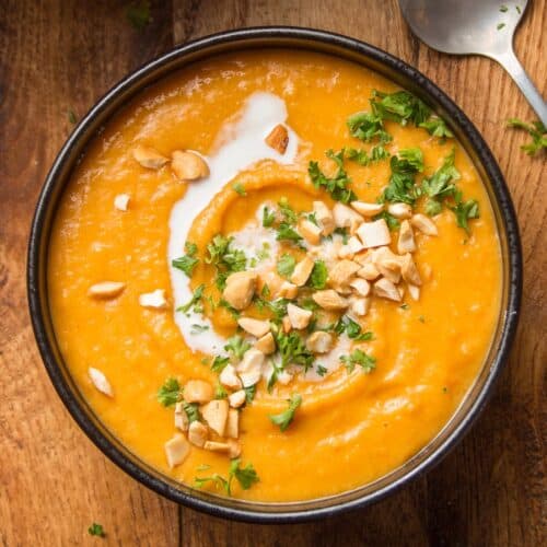 Bowl of Sweet Potato Soup Topped with Coconut Milk and Peanuts