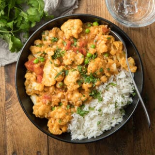 Bowl of Cauliflower Curry and Rice on a Wooden Surface