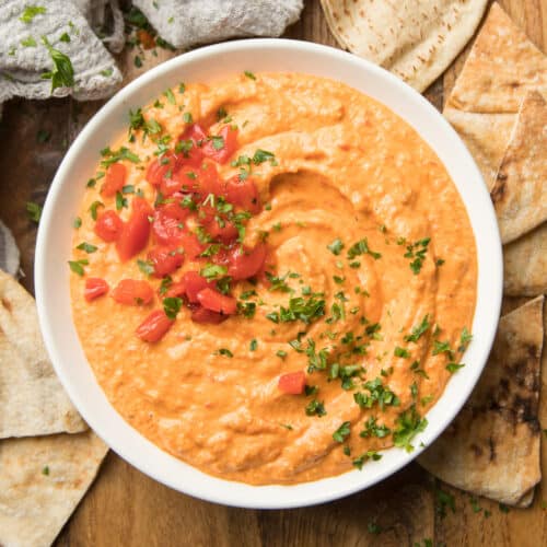 Bowl of Roasted Red Pepper Hummus with Roasted Red Peppers and Parsley on Top