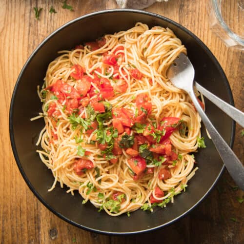 Bowl of Tomato Basil Pasta with Fork and Spoon