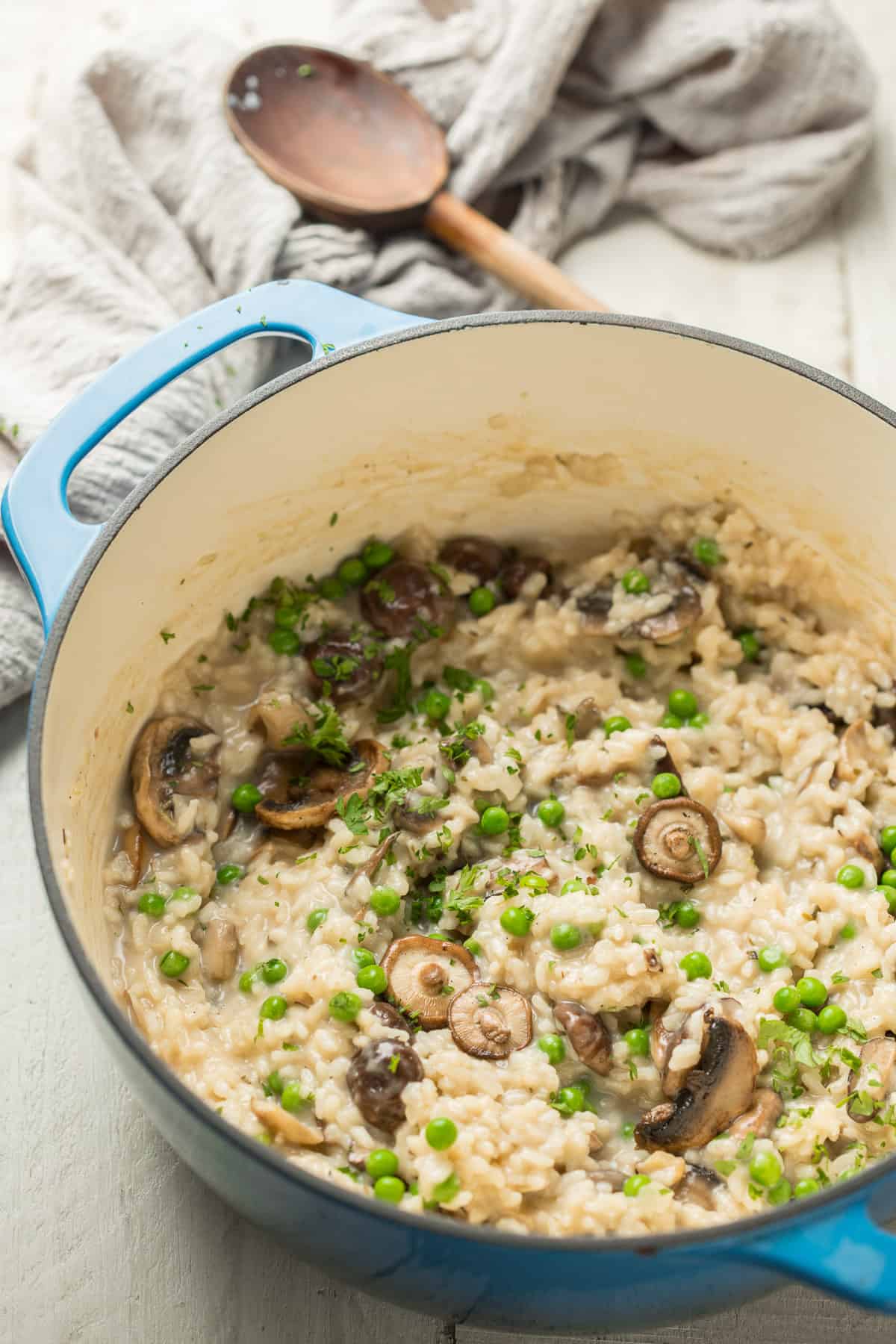 Pot of Vegan Mushroom Risotto with wooden spoon in the background.