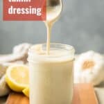 Spoon drizzling tahini dressing into a jar with text overlay reading "creamy Tahini Dressing".