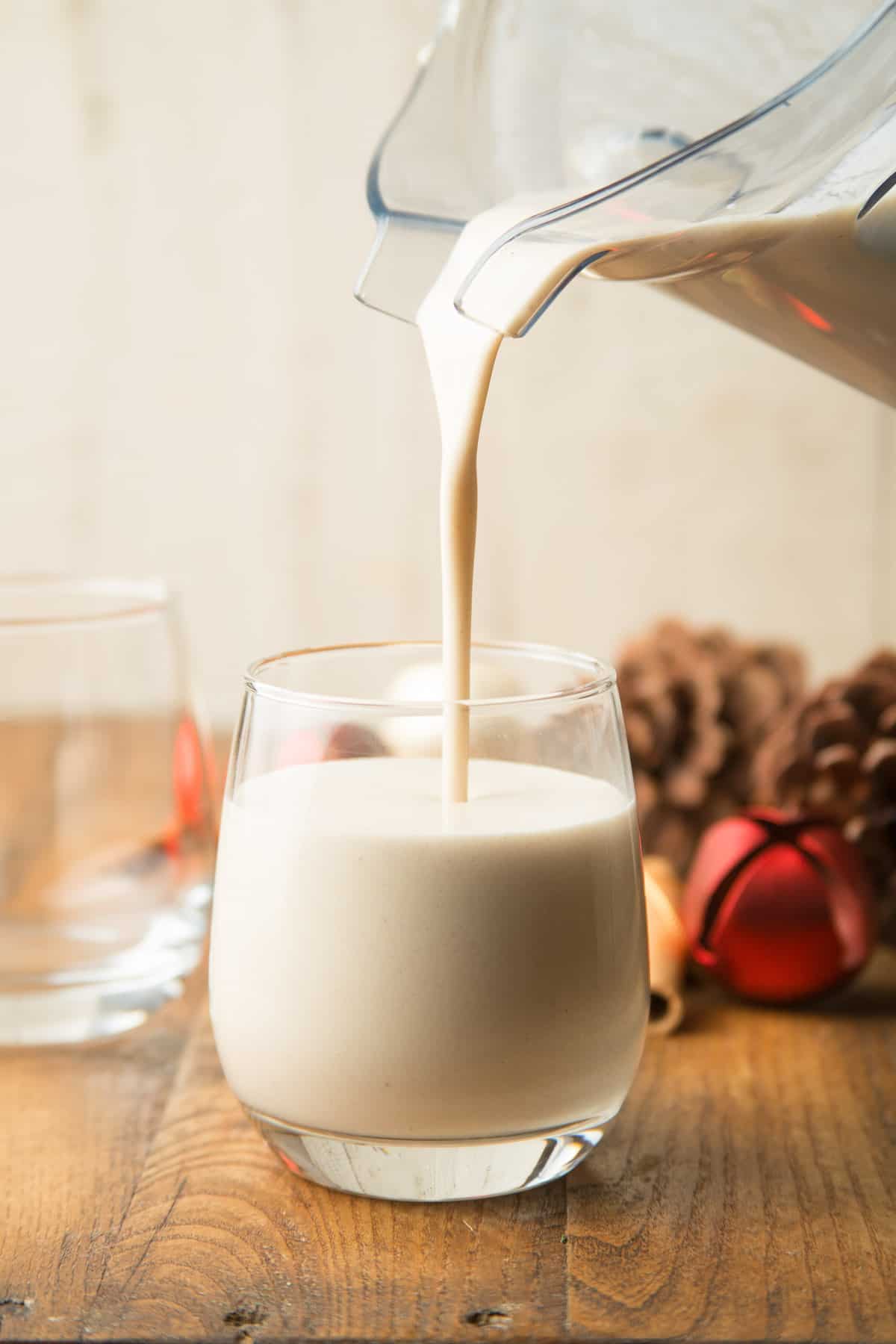 Vegan Eggnog being poured from a blender into a glass.