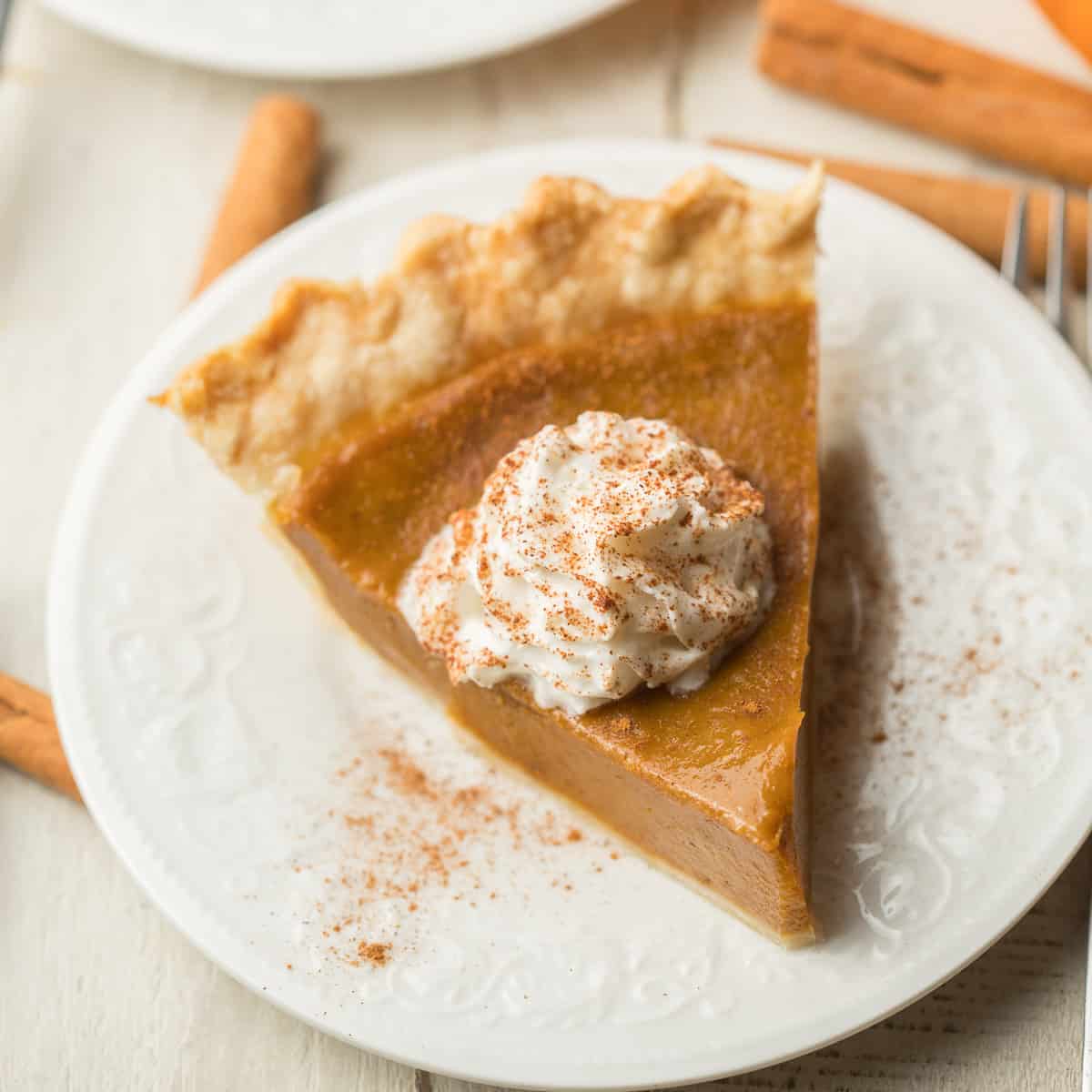 SSlice of Vegan Pumpkin Pie on a plate with whipped topping.