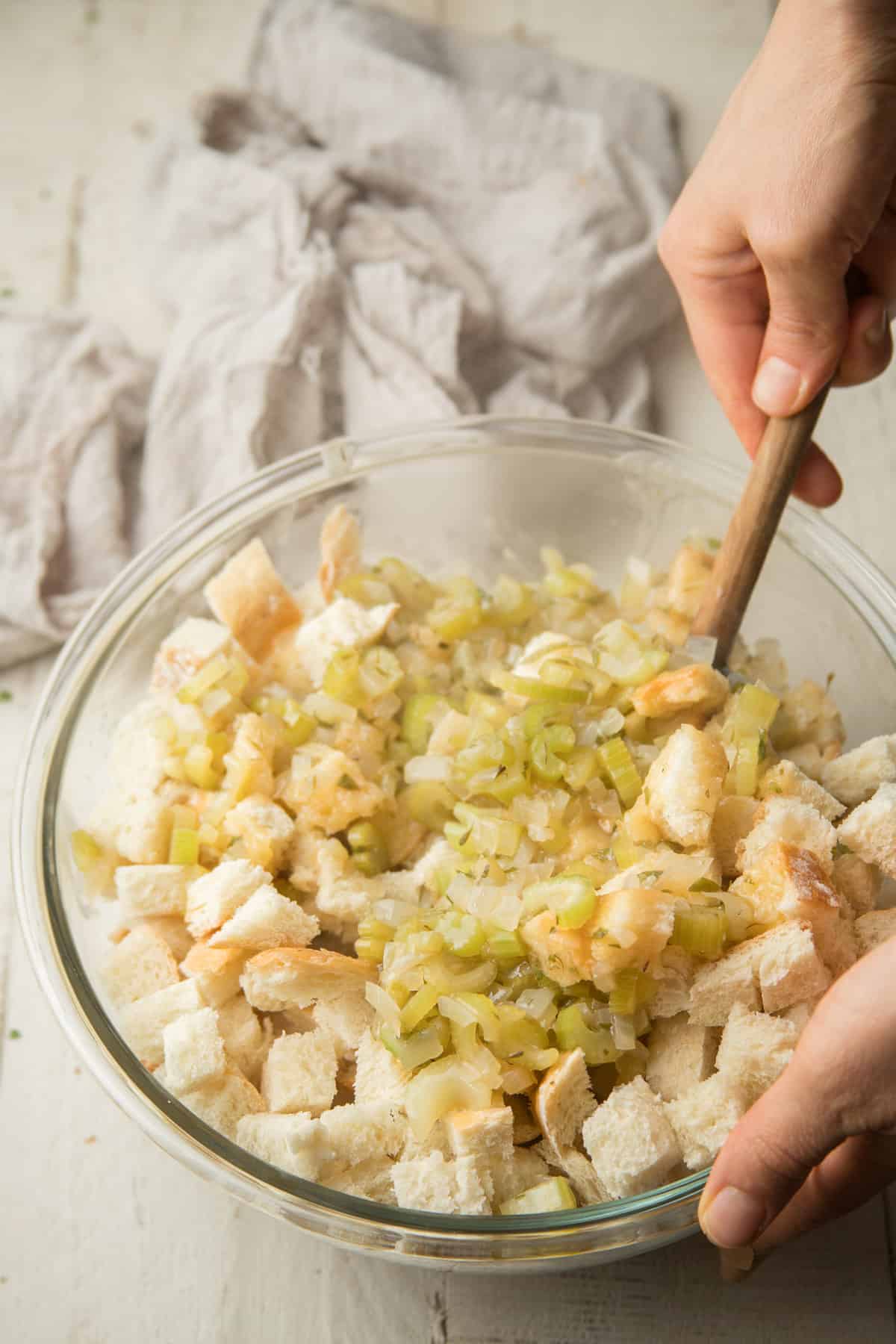 Hand Stirring Vegan Stuffing ingredients together in a bowl.