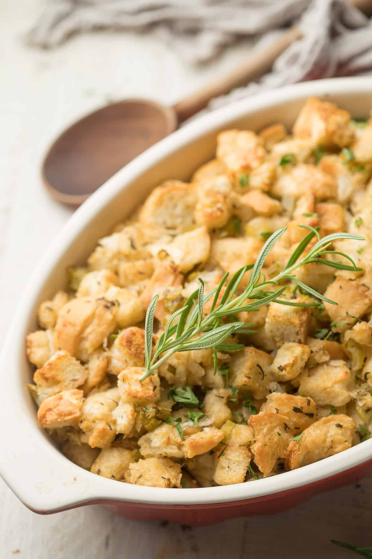 Vegan Stuffing in a dish topped with a sprig of rosemary.