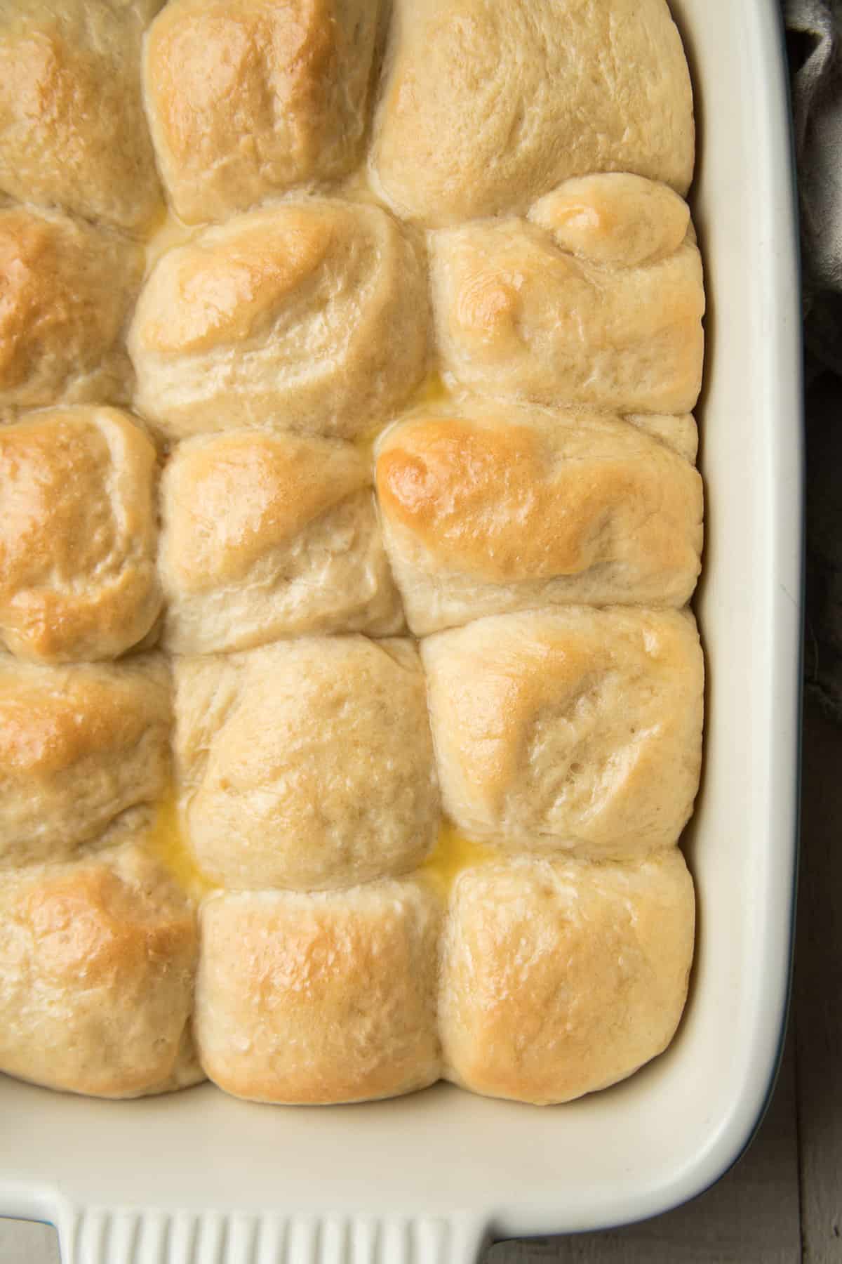 Vegan Dinner Rolls with melted butter on top in a baking dish.
